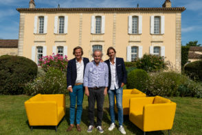Three people with yellow chairs on lawn