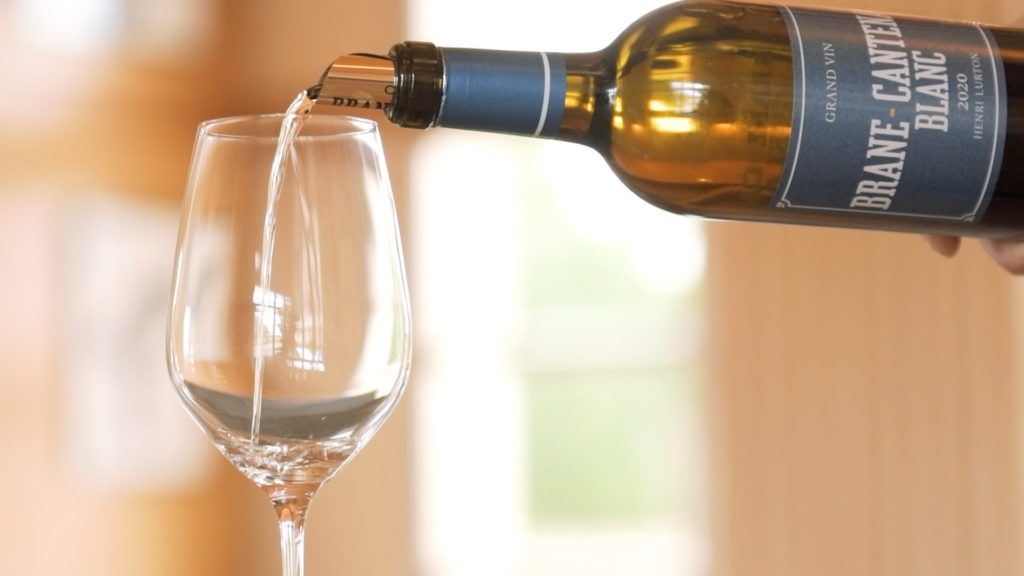 twins-chateau-brane-cantenac-pouring-white-wine-into-glass-negociant-bordeaux
