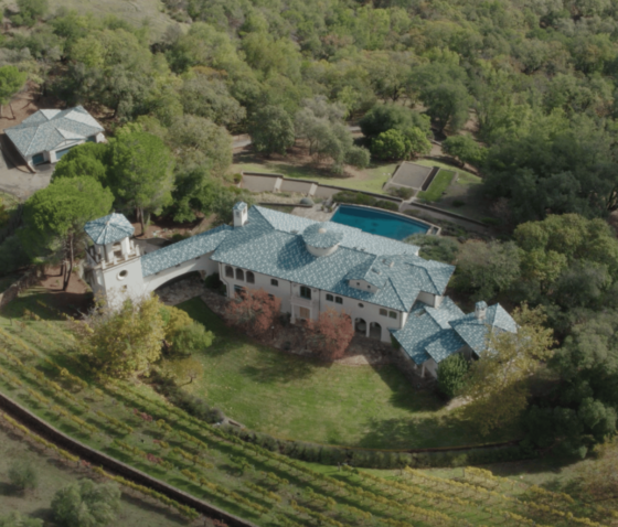 Aerial view of house with blue roof and pool